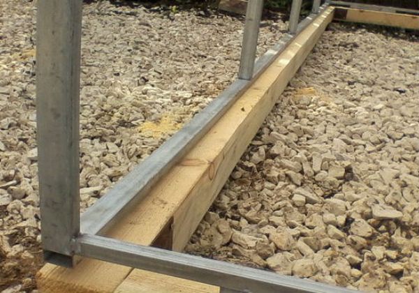 Montering af en metalramme på et træfundament Montering af en metalramme på et træfundament